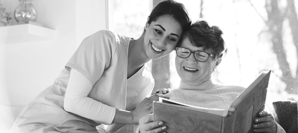senior woman and caregiver reading